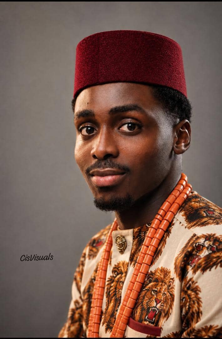 Man in traditional Igbo attire with a maroon cap and coral beads
